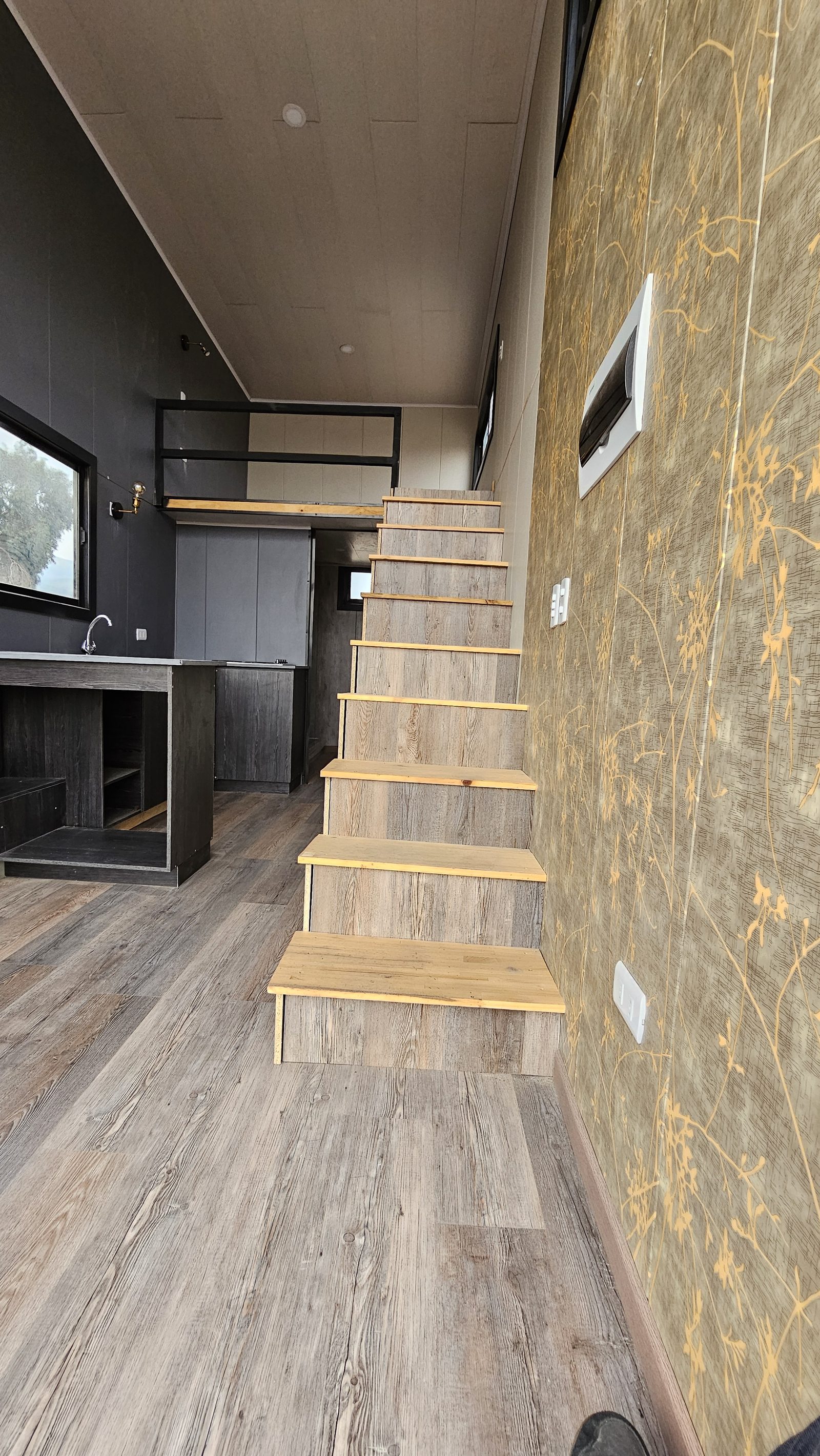 Escalera interior de madera hacia el segundo piso