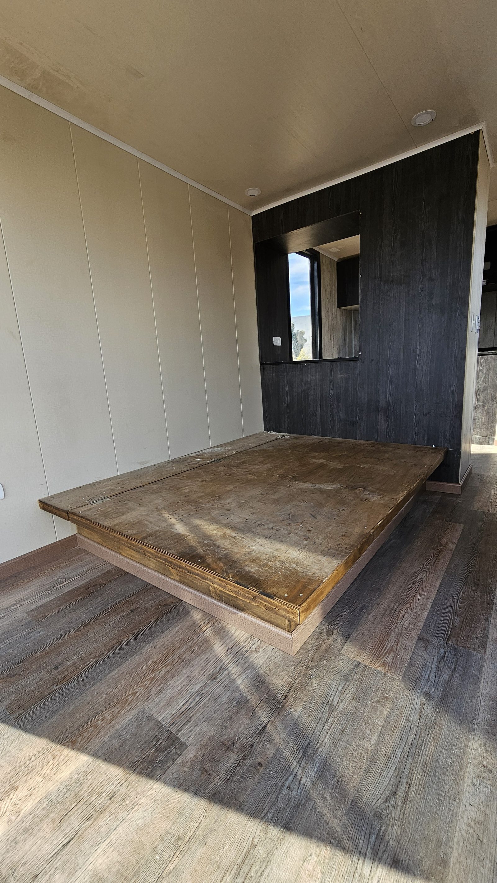 Dormitorio con cama en plataforma de madera